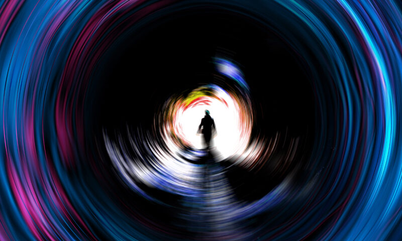 A swirling, tunnel-like vortex of neon blues, purples, and pinks pulls the eye inward toward a bright center, where a lone silhouetted figure walks forward.