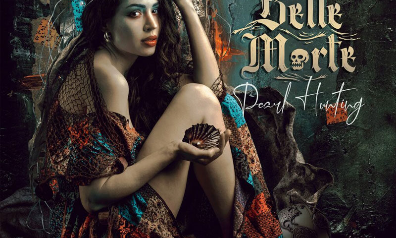 The album cover for Pearl Hunting by Belle Morte features a woman with long, wavy hair sits in a contemplative pose, adorned in a bohemian-style dress with rich, earthy tones and intricate patterns. She holds a small seashell in her hand. The background blends elements of fantasy and gothic imagery, with glowing strands resembling bioluminescent filaments in her hair. The typography is ornate, with the album title written in a flowing script, while the band's name is styled in a gothic font with a subtle skull motif.