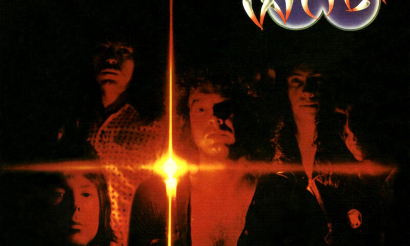 The album cover for Cadenza: The Complete Recordings 1973–1974 by Darryl Way’s Wolf features the band members illuminated by a fiery orange-red light that radiates in a cross-shaped flare against a dark background. The band's name appears at the top with a wolf’s head above the “O,” while the album title and subtitle are printed in white at the bottom right.