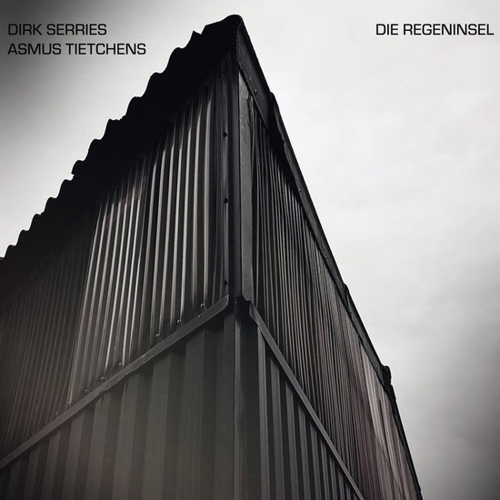 Dirk Serries and Asmus Tietchens - Die Regeninsel cover artwork. The cover of Die Regeninsel features an upward-looking photograph of a corrugated metal structure shot from a corner angle. The artists' names appear in the upper left corner, while the album title sits opposite in the upper right.