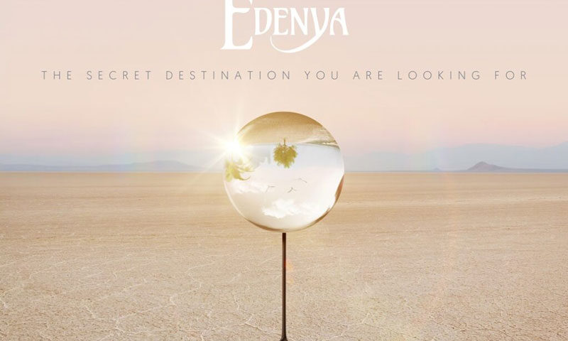 The album cover for Edenya – The Secret Destination You Are Looking For features a desert landscape under a soft pink sky. At the center stands a reflective orb on a tripod, capturing an inverted image of a scene with palm trees and birds. The band's name appears above in stylized white lettering, while the album title is set below in minimalist uppercase text.