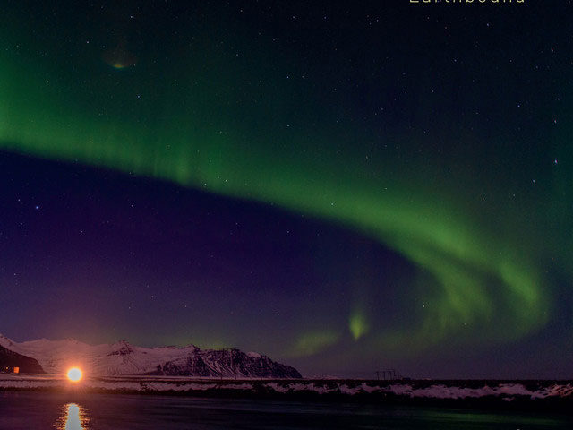 Eivind Austad Trio - Northbound cover artwork. a distant coastal landscape and a sky with the aurora borealis.