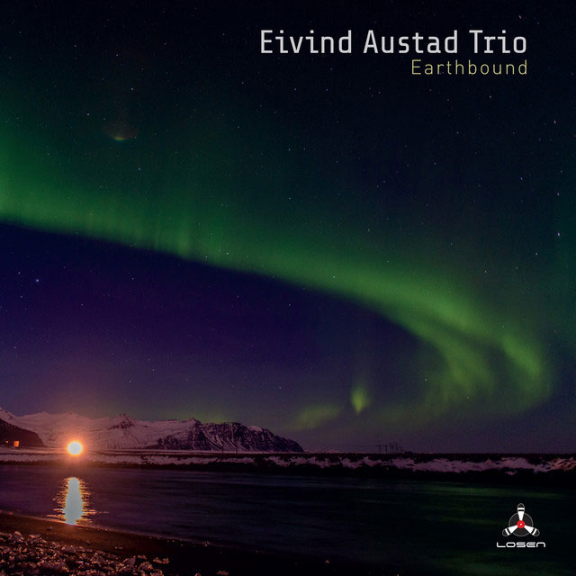 Eivind Austad Trio - Northbound cover artwork. a distant coastal landscape and a sky with the aurora borealis.