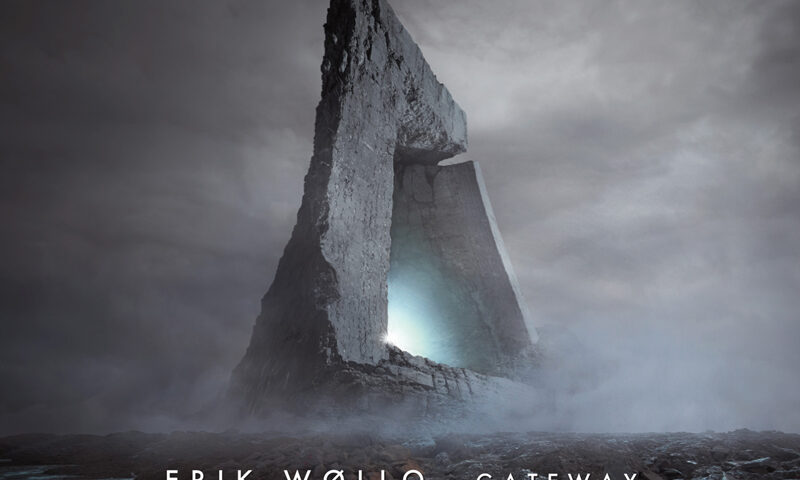 The album cover for Gateway by Erik Wøllo features a towering, monolithic stone structure shaped like an abstract arch or portal, set against a desolate, misty landscape. A soft, ethereal blue light glows from within the gateway.