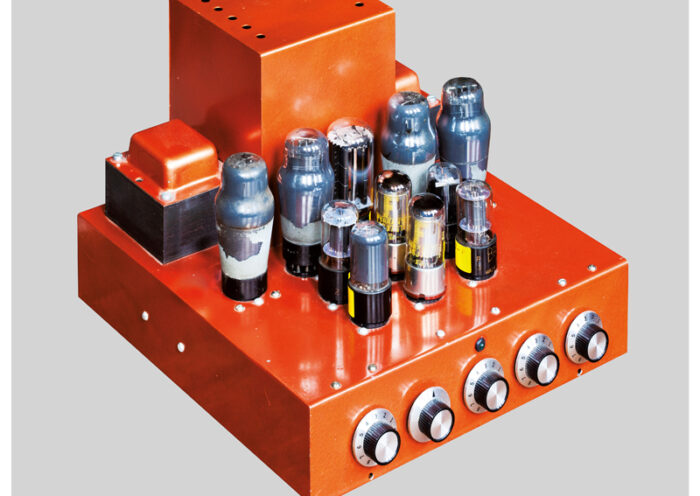 The album cover for Frost*'s Western Atmosphere features a striking image of a bright orange, retro-style tube amplifier against a neutral gray background. The minimalist layout highlights the amplifier's intricate design, with its glowing vacuum tubes and tactile knobs. The band's name and album title appear in clean, modern typography at the bottom.