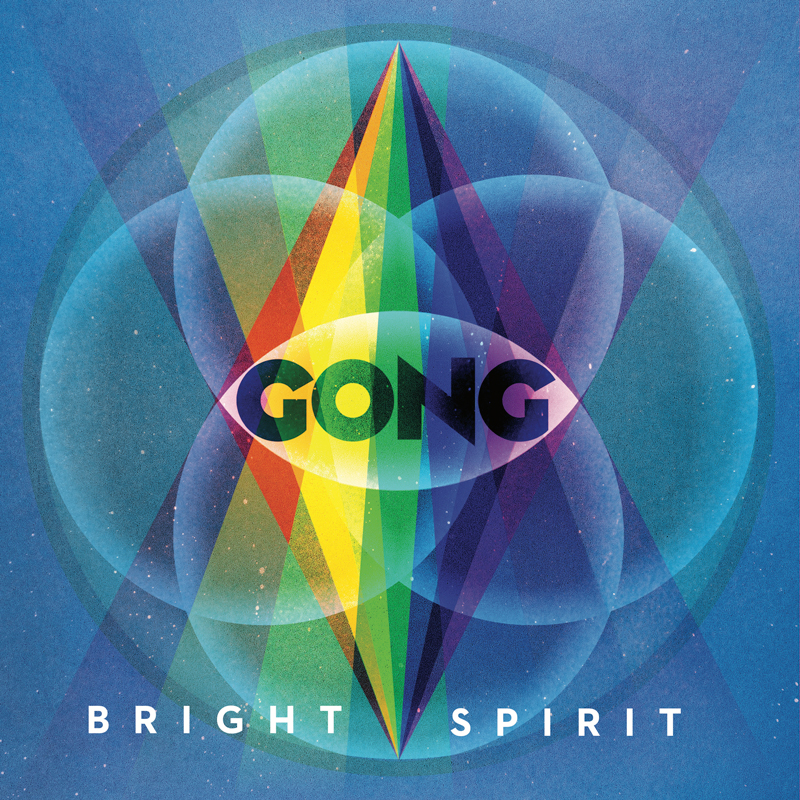 The cover of Bright Spirit by Gong presents a symmetrical, geometric design set against a deep blue background. At the center, a tall prism splits into bright rainbow beams that extend vertically through the composition. Overlapping translucent circles form a mandala-like pattern around the prism, creating an eye motif with the word “GONG” placed across its center. The album title appears below in spaced white letters.