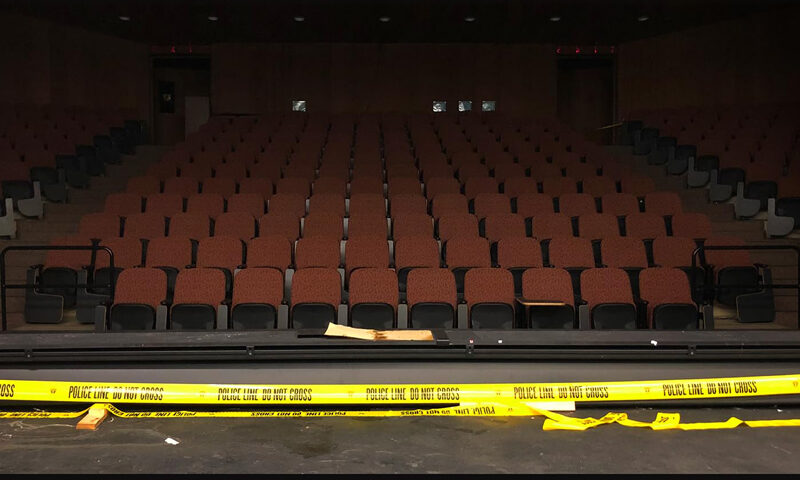 The album cover shows an empty theater with rows of red seats, viewed from the stage. Yellow police tape stretches across the front. The title Hermetic Science appears at the top, and Live at Innsmouth is written at the bottom in bold white letters.