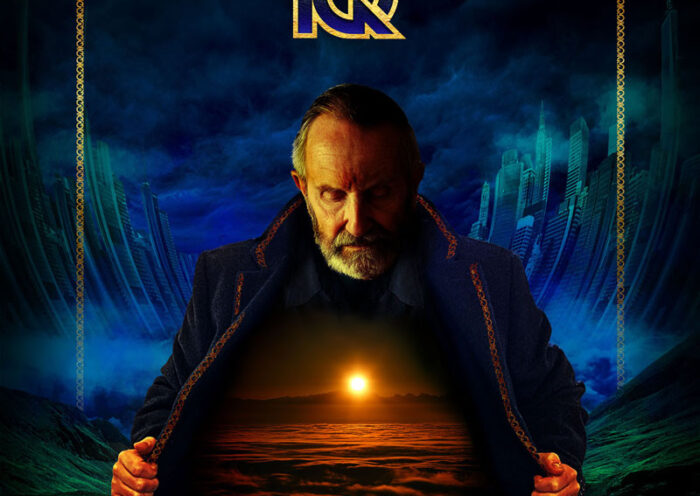 IQ's Dominion album cover features at the center an older man with a stern expression and a trimmed beard. He opens his dark, ornate coat to reveal a glowing scene within—a vast, otherworldly landscape illuminated by a golden sunset over a sea of clouds. The background contrasts futuristic cityscapes with ominous stormy skies. The band's logo appears at the top in gold, while the album title, Dominion, is subtly placed within the illuminated scene on his chest.