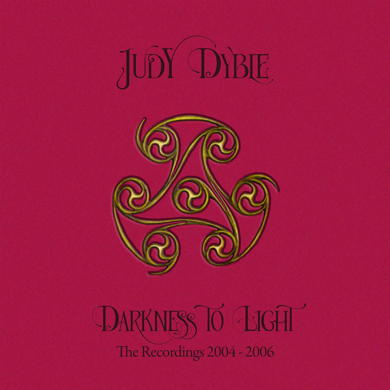 The album cover for Judy Dyble – Darkness to Light: The Recordings 2004–2006 features a rich magenta background with elegant, calligraphic black text. At the center is a gold and green Celtic-inspired triskelion symbol.