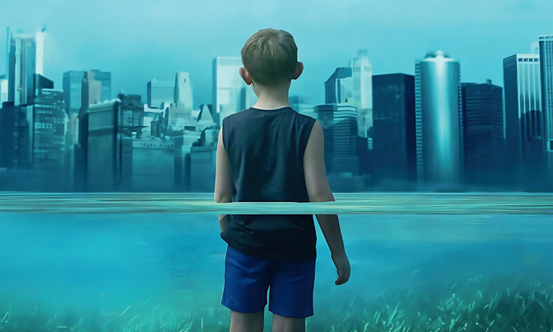 The album cover for Age of Fragility by Marco Mattei features a young boy standing in shallow water, facing a futuristic city skyline in the distance. The waterline cuts through the middle of the image, symbolically dividing nature (grass beneath his feet) and urbanization.