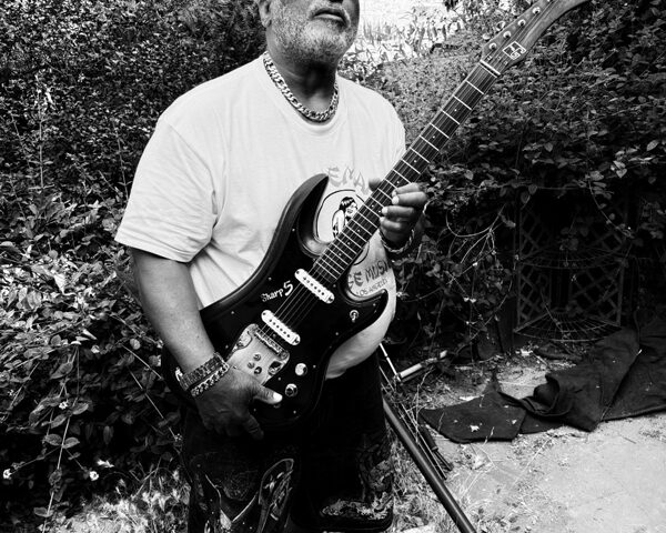 Michael Hampton holding an electric guitar. Black and white photo.