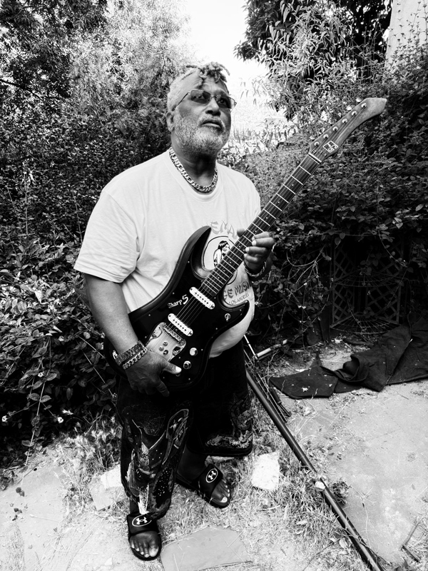 Michael Hampton holding an electric guitar. Black and white photo.
