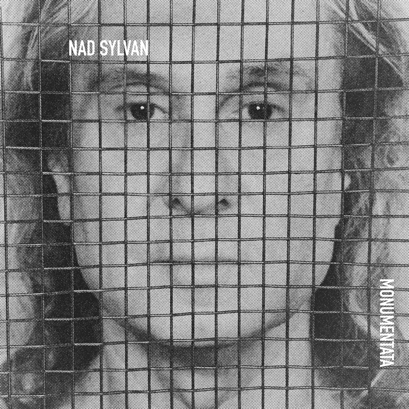 The album cover for Monumentata by Nad Sylvan features a grayscale, close-up photo of Sylvan’s face, obscured by a grid or mesh overlay. The artist's name appears in small white text in the top left, while the album title is rotated vertically in the bottom right.