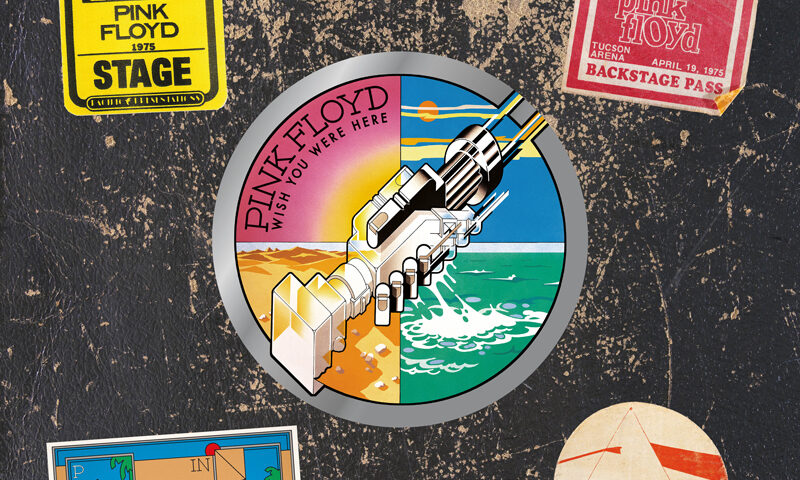 The 50th anniversary 3LP edition of Wish You Were Here features a collage-style cover. At its center is the classic artwork of two robotic hands shaking, split into four vivid quadrants: desert, ocean, sky, and sunset. Surrounding this emblem are colorful vintage tour stickers and backstage passes from Pink Floyd’s 1975 shows, all set against a black background resembling a worn road case.