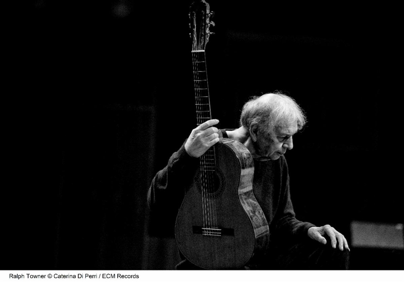 Ralph Towner - photo by Caterina Di Perri. Black and white photo of Towner holding his guitar.