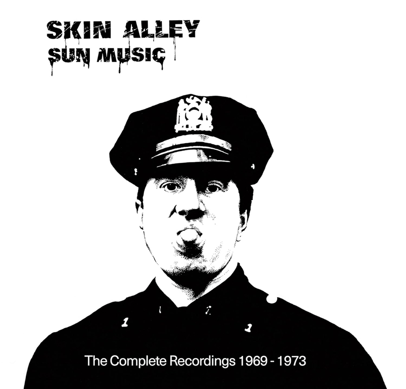 The album cover for Skin Alley – Sun Music: The Complete Recordings 1969–1973 features a black-and-white image of a uniformed policeman sticking out his tongue. The band and album title appear in stencil-style lettering at the top left, while the subtitle is centered at the bottom.