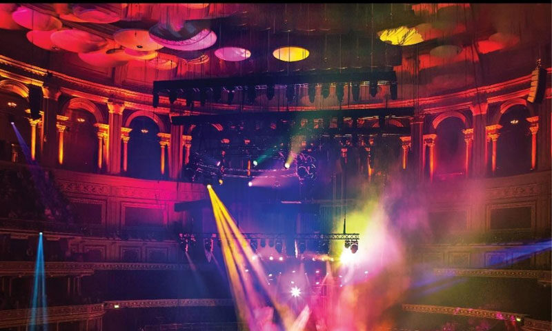 The album cover for The Lamb Stands Up Live at the Royal Albert Hall features a wide-angle photo of Steve Hackett's live performance at the iconic venue. Bathed in multicolored stage lights and surrounded by the ornate architecture of the Royal Albert Hall. The artist's name and album title appear in classic serif font against a black header.