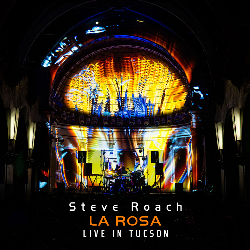 Steve Roach La Rosa cover artwork. A live image of Roach on stage with multiple colors of light.