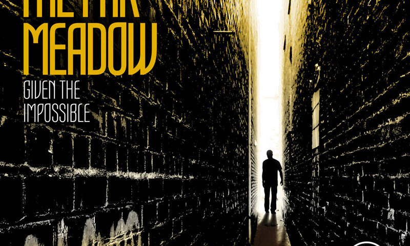 The album cover for The Far Meadow - Given the Impossible features a striking visual of a narrow, graffiti-lined alleyway bathed in golden light. At the end of the alley, a lone silhouette of a person stands illuminated by a bright glow. The bold yellow typography contrasts with the dark, textured brick walls. The band's initials, "TFM," appear subtly in the bottom corner.