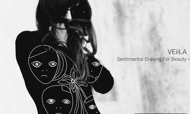 VEiiLA – "Sentimental Craving for Beauty - Deluxe Edition cover artwork. A photo of a woman with sunglasses. Her black dress has faces drawn on it.