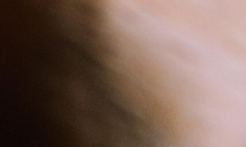 The album cover for Slow and Looped by Volker Lankow features a soft blur in warm brown and beige tones. The artist's name and album title appear in lowercase at the bottom in a serif font against a dark brown band.
