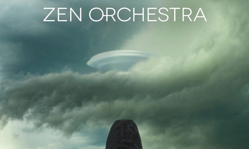 A hooded figure stands beneath a swirling sky as a UFO emerges from the clouds. Above, the title Zen Orchestra appears.