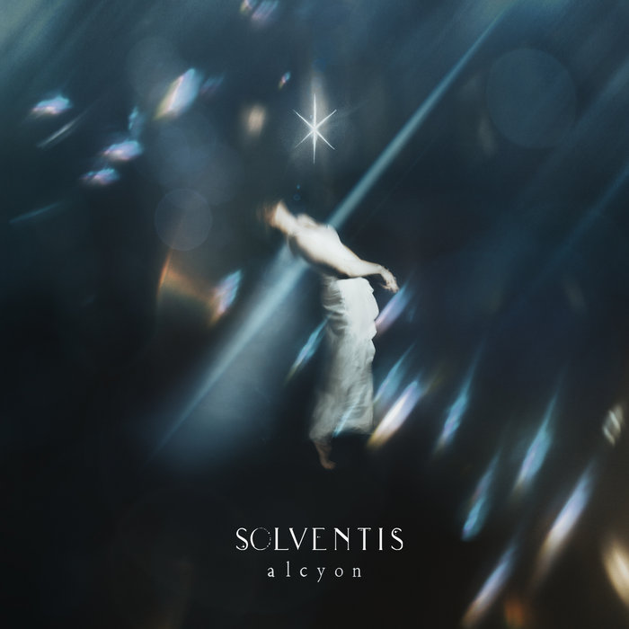 Solventis – "Alcyon" cover artwork. An image of a woman under a spotlight.