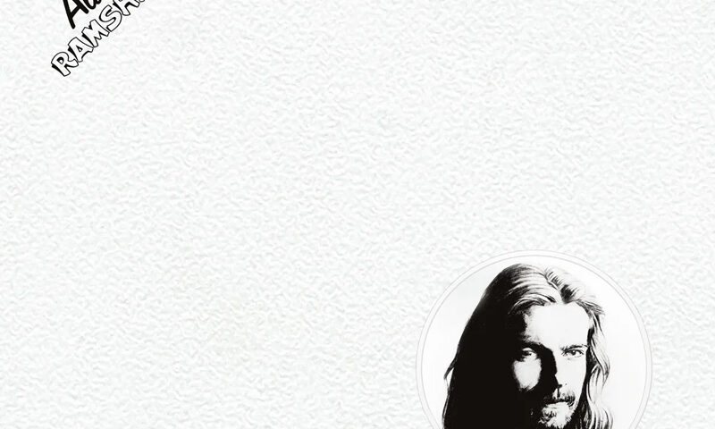 The cover of Ramshackled is a white, textured background with only two key elements, a small circular black-and-white portrait of Alan White in the bottom right, and the album title with his name in black lettering at the top left. The design feels understated, almost blank, drawing attention to White’s face and the album’s name.